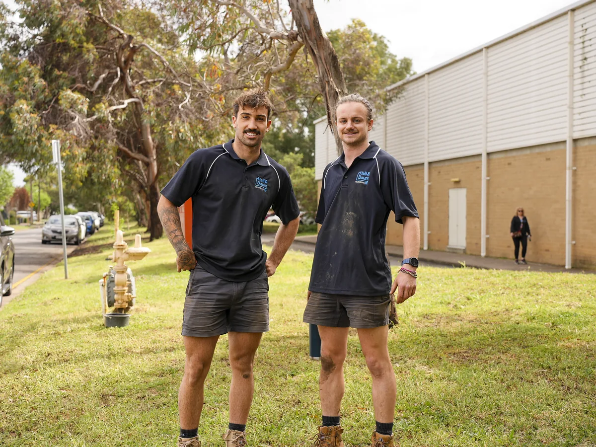 Two Hall & Baum team members in blue uniforms