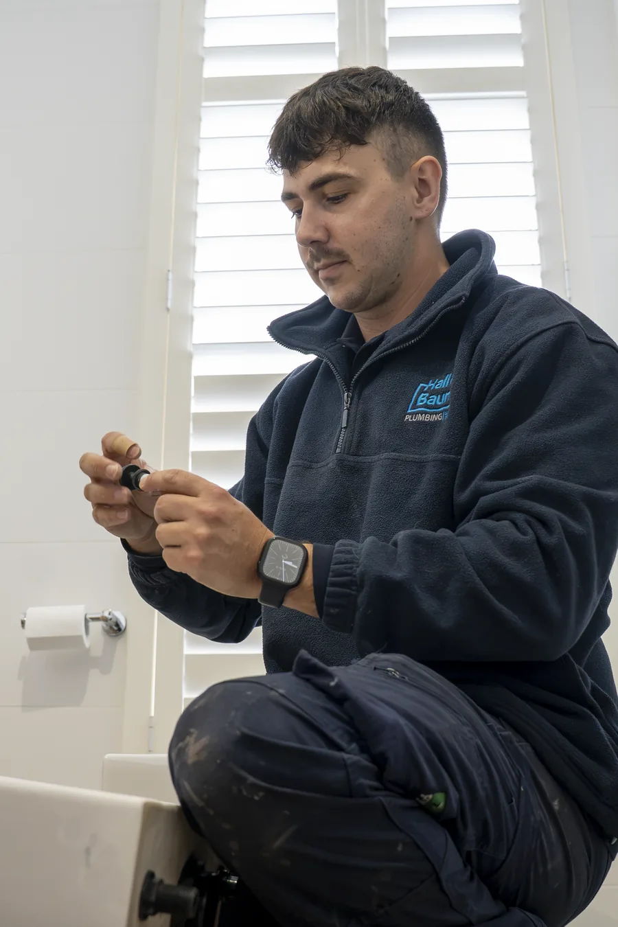 Hall & Baum plumber repairing a toilet