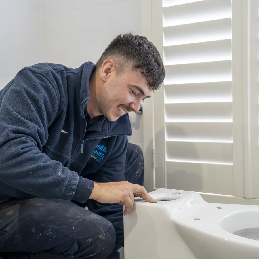 Hall & Baum plumber servicing a toilet